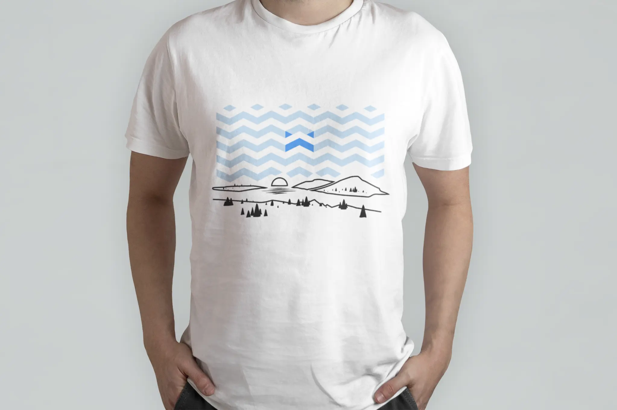 White t-shirt with blue chevron pattern and mountain landscape illustration